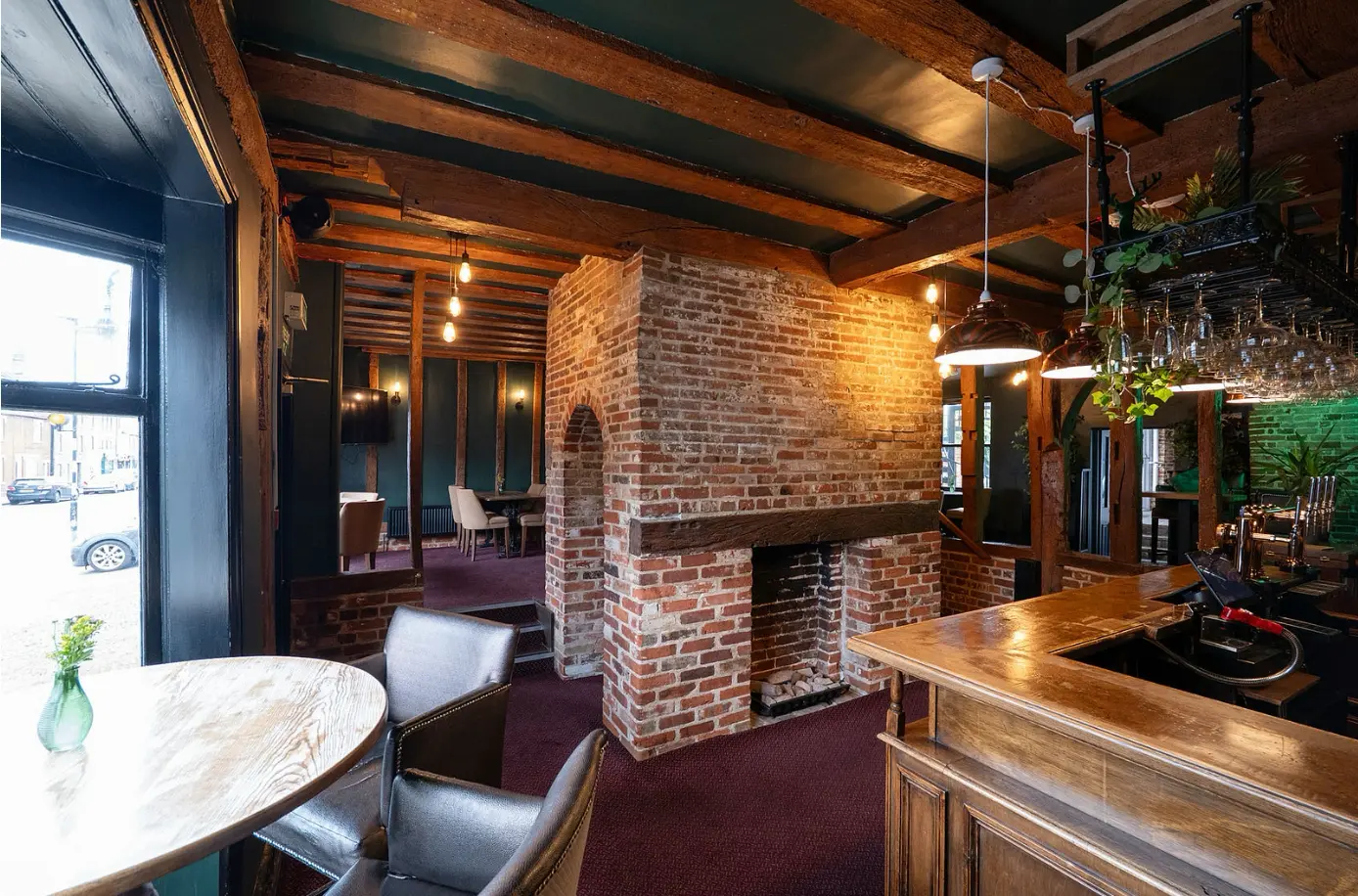 The Upper Bar at The Limes — exposed brick fireplace and beamed ceiling