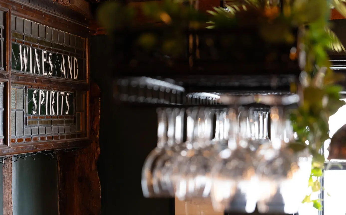 Wines and Spirits sign with hanging glasses at The Limes Bar
